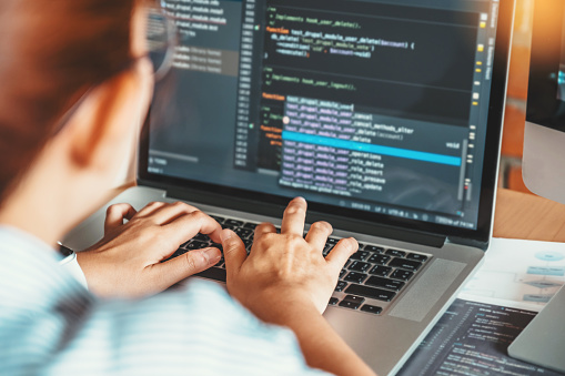 Desarrolladora trabajando en código desde su computador, ejemplo de material desarrollado por TERVEZE